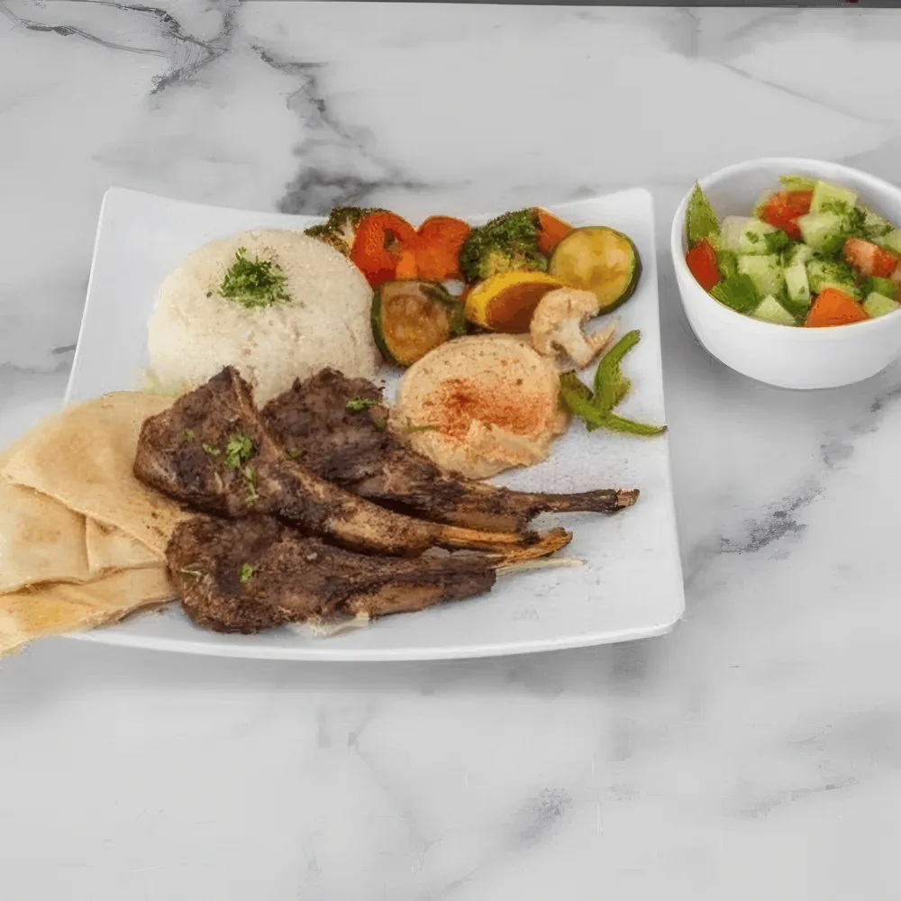 Bone-in lamb chops platter with rice, hummus and salad