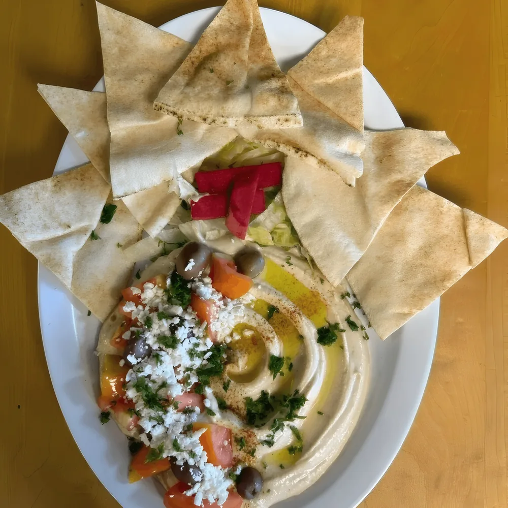 Lily's Ultimate Hummus topped with feta, olives and tomato, with pita